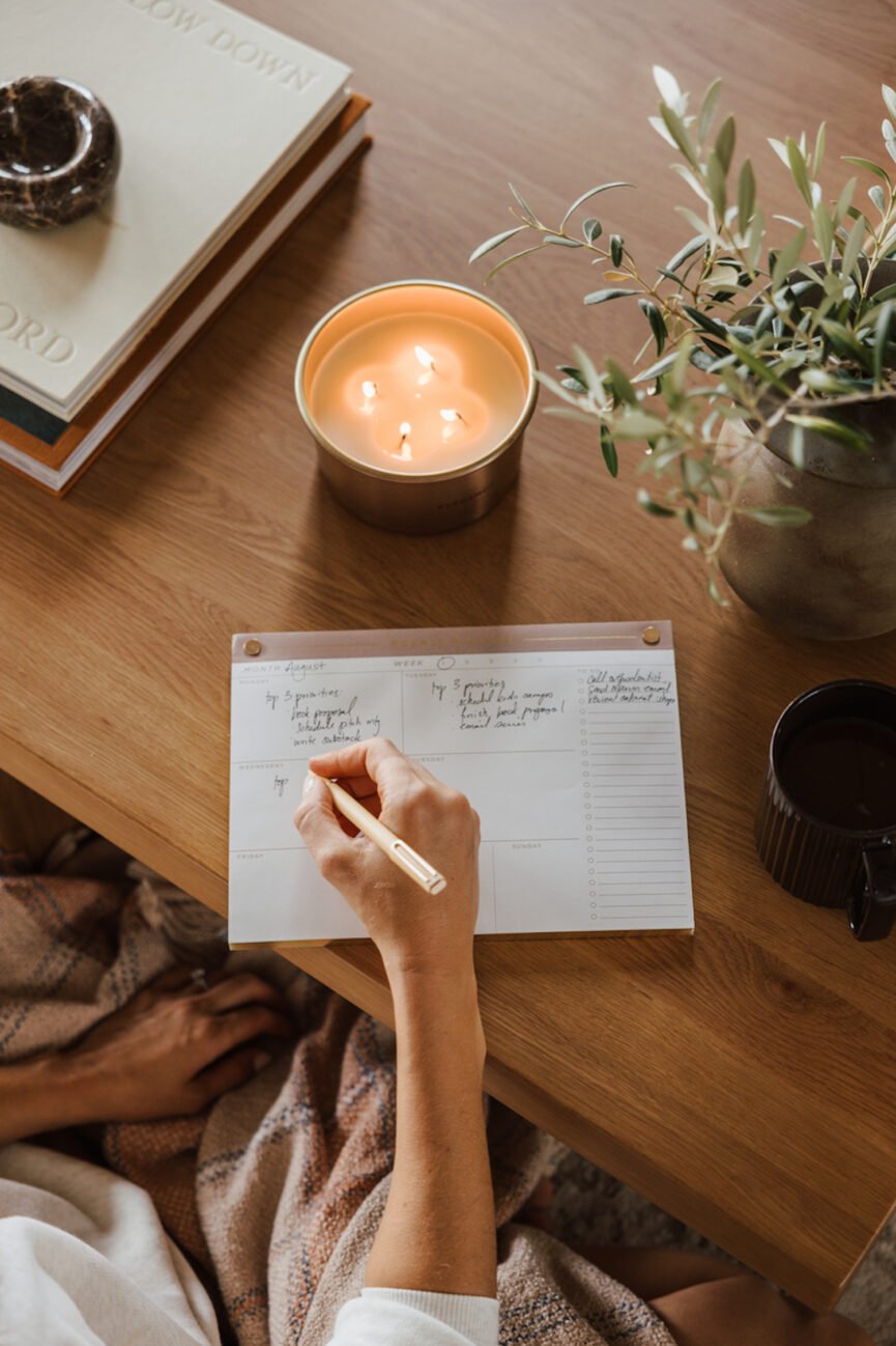Woman writing about a mental glow up in journal.